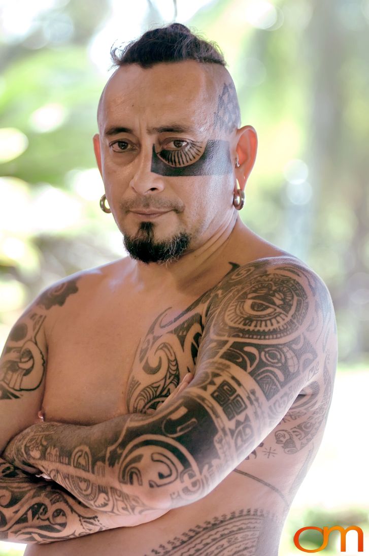 Photo of Polynesian traditional tattoos on a man's face, arms, and chest. Taken of Chimi on the island of Mo'orea by Amanda Fornal in October 2006.