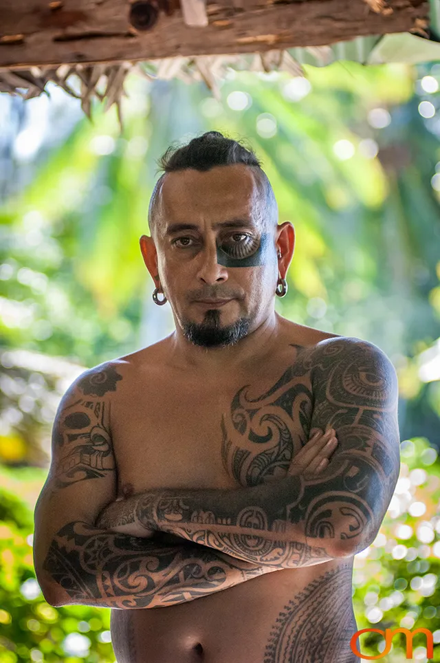 Photo of Polynesian traditional tattoos on a man's face, arms, and chest. Taken of Chimi on the island of Mo'orea by Amanda Fornal in October 2006.