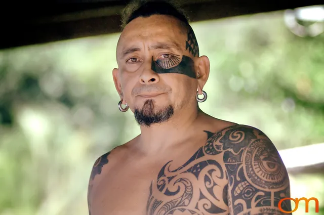 Photo of Polynesian traditional tattoos on a man's face, arms, and chest. Taken of Chimi on the island of Mo'orea by Amanda Fornal in October 2006.