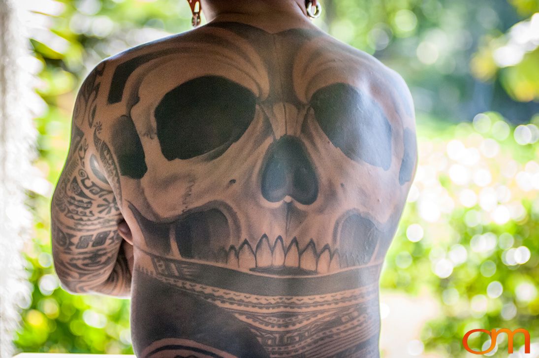 Photo of back of man's back with a skull tattoo. Taken of Chimi on the island of Mo'orea by Amanda Fornal in October 2006.